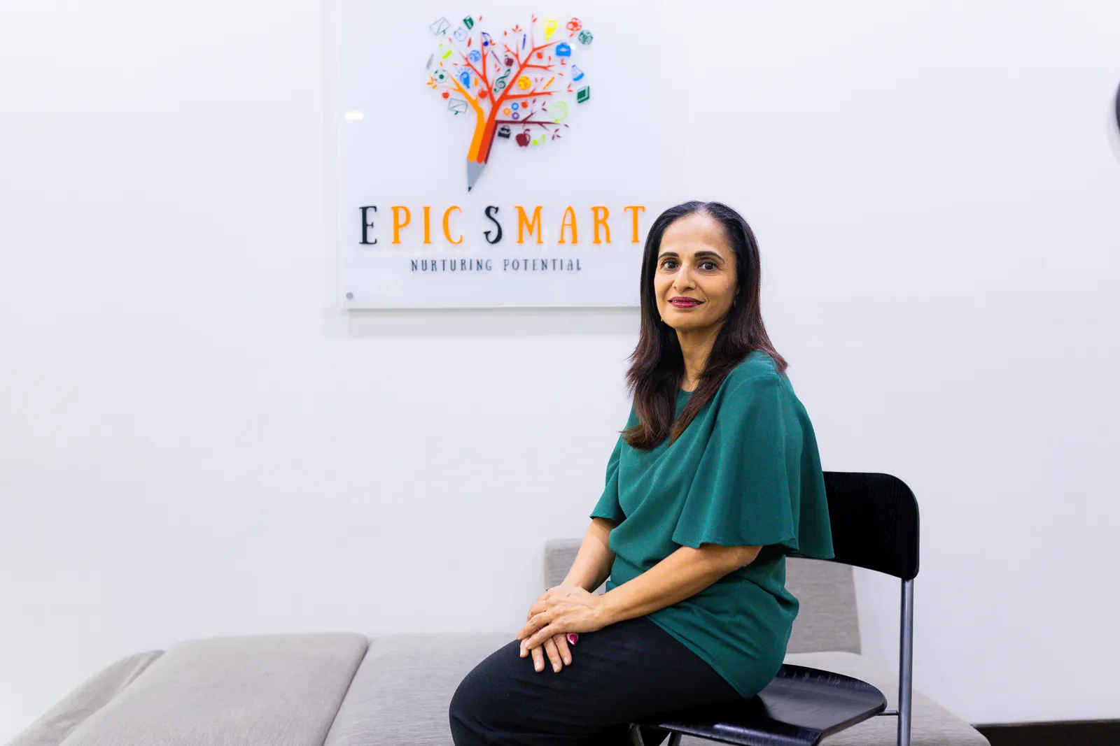 Mrs Mayurni Patel, founder of Epic Smart Academy, seated beneath the centre's logo in Bangsar