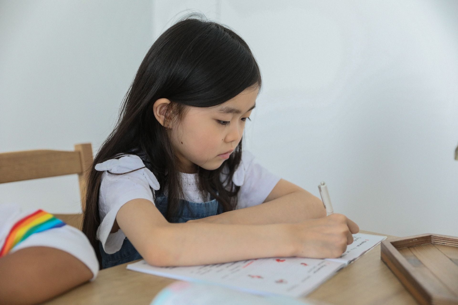 Student concentrating on Additional Mathematics homework at a desk