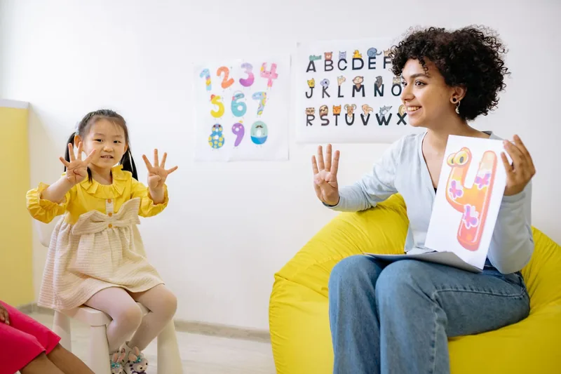 A teacher making early numeracy fun for a young learner