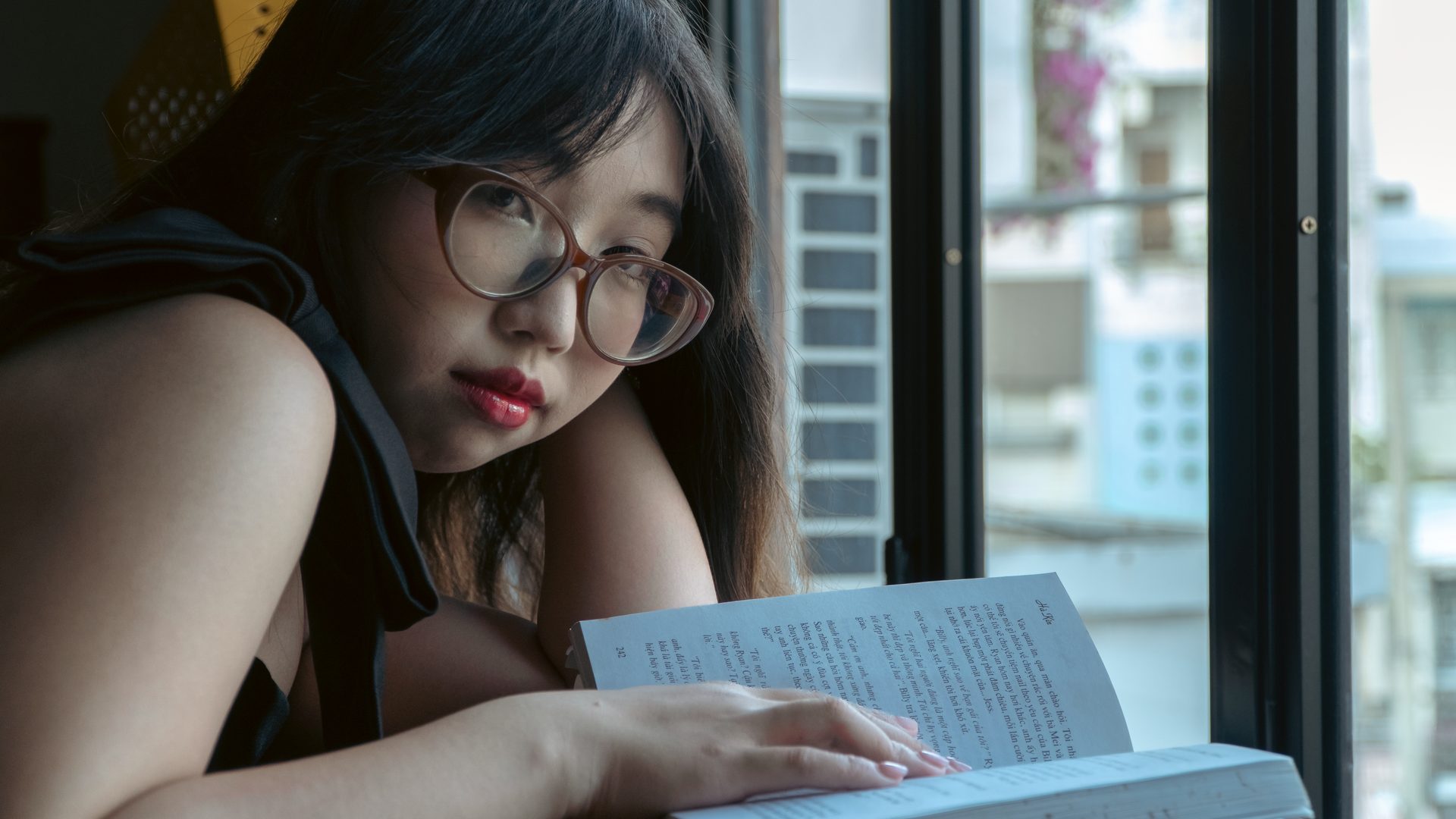 Student reading an English book while studying independently