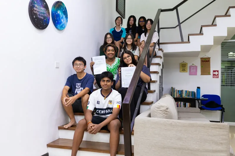 SPM and secondary students with their teacher holding Add Maths exam practice books at Epic Smart Academy