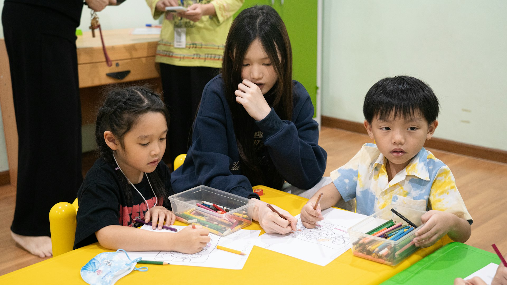 Preschool teacher guiding children through a drawing activity