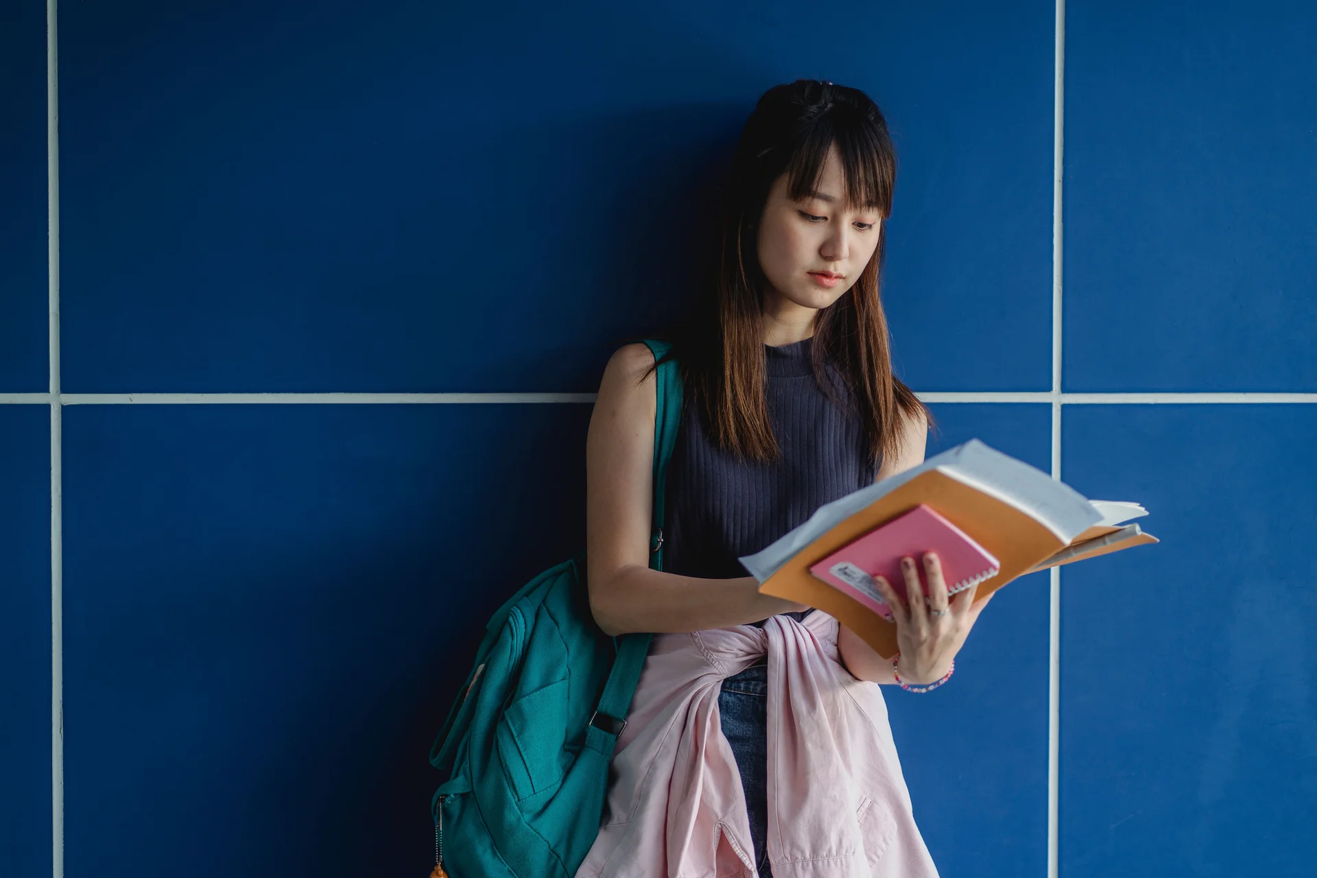 A student working through exercise books at a desk
